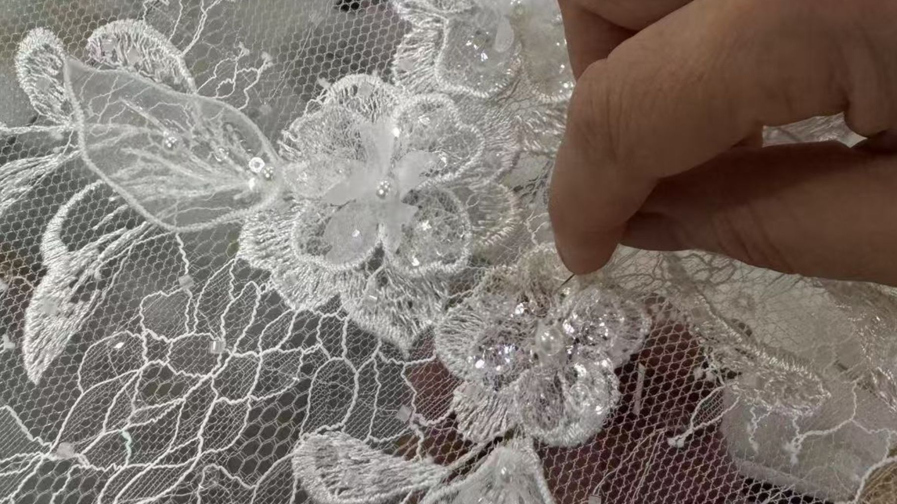 A close-up of intricate 3D floral lace fabric